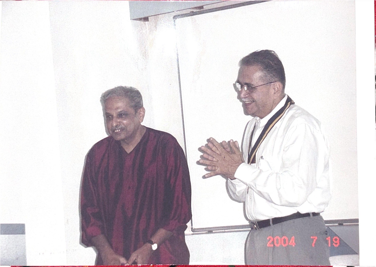 Club president welcoming a guest speaker at a 2004-05 meeting