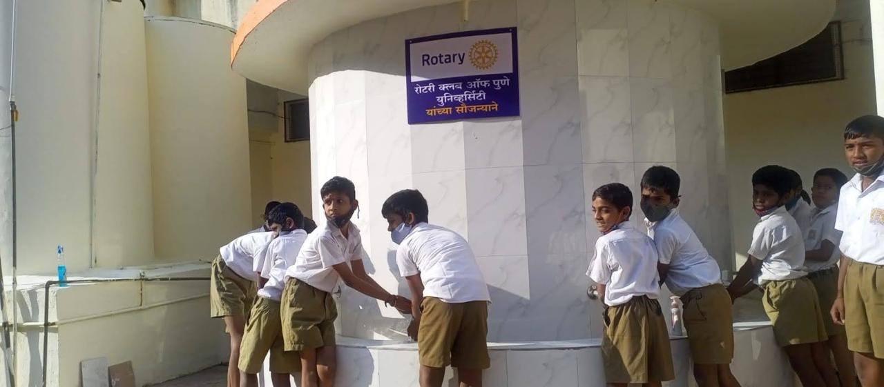Schoolchildren washing their hands at the station built by the club